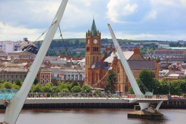 DERRY, İngiltere - 24 Haziran 2024: Yayalar Kuzey İrlanda 'da Derry' deki Barış Köprüsü 'ndeki Foyle nehrini geçtiler.