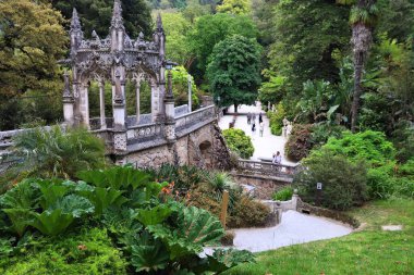 SINTRA, PORTUGAL - 21 Mayıs 2018: İnsanlar Sintra 'daki Quinta da Regaleira bahçelerini ziyaret ediyor. Quinta da Regaleira Portekiz Ulusal Anıtı ve UNESCO Dünya Mirası Alanı olarak listelenmiştir..