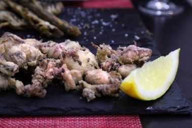 Tapas küçük İspanyol yemekleri. Alicante 'de İspanyol mutfağı. Chipirones - siyah tahtada servis edilen kızarmış bebek kalamar..