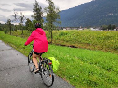 Avusturya, Carinthia 'da Gailradweg' de uzun mesafe bisiklet yolu üzerinde kask takan kadın bisikletçi..