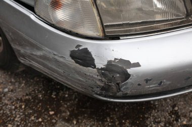 Ön tamponunda hasar olan klasik gümüş bir araba. Tampon boyasında hasar var. Çatlak ve pullu kaplama. Küçük bir kaza sonucu - İspanya 'da ufak bir kaza..