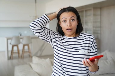 Şok olmuş akıllı telefonlu bir kadın beklenmedik bir mesaj aldı. Ağzını açıp kameraya bakan hayret verici bir kadın evde şaşkınlık içinde. İnanılmaz bir satış, online mağaza teklifi.