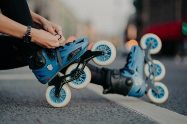 Yüzü olmayan bir kadının yatay çekimi aktif sporda kullanılan şehir geçmişine karşı yolda paten sürerken pozlar verir. İnsanların hobisi ekstrem spor, aktif yaşam tarzı konsepti.