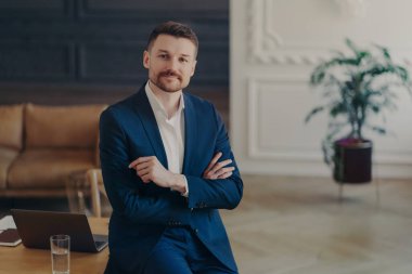 Resmi koyu mavi takımla gülümseyen ve lükse güvenen genç yakışıklı iş adamının portresi mi yoksa çalışma masasında dizüstü bilgisayar, kalem ve bir bardak suyla oturan ev idaresi mi?