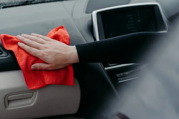 Hand wiping car interior with rug. Disinfection and cleaning concept. Killing coronavirus on touching surface of auto. Console car washing concept