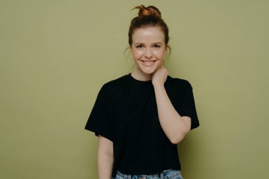 Siyah tişörtlü, saçları topuz gibi olan çekici kız ne diyeceğini bilemez, kararsız kalır, yeşil duvara yaslanırken el ele tutuşur ve olumlu duygularını ifade eder.