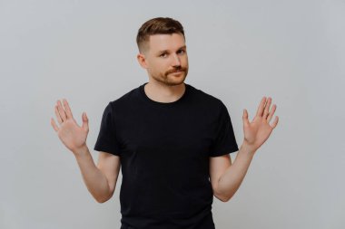 Hayır demek. Siyah tişörtlü genç adam reddediyor ya da jesti durduruyor. Stüdyoda gri arka planda dikilirken onu rahatsız etmemesini istiyor. İnkar kavramı
