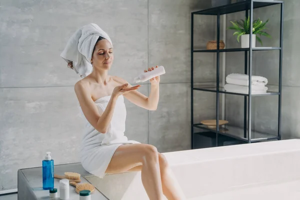 Sıska Güzel Bir Kadın Banyoda Cilt Bakımı Sırasında Şişeden Losyon — Stok fotoğraf
