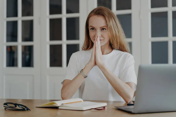 Sophisticated woman sitting with her hands folded and relaxing. Mid adult businesswoman is working from home. Lovely european lady has remote work at the desk. Concept of confidence and success.