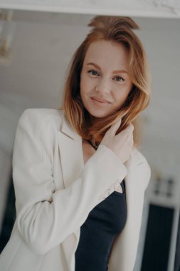 Mutlu, orta yaşlı bir kadının aynadaki yansıması. Akşam evine bakıyor. Beyaz bir ceket ve siyah bir gece elbisesi. Sevimli Avrupalı bayan partiye gidiyor. Moda kıyafetleri..