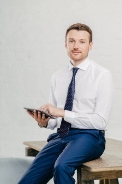 Ciddi iş adamı dikey shot finansal haber online okumak için modern tablet bilgisayar kullanır, bankacılık yapar, web sayfası, kablosuz internet'e bağlı gözatar. İnsan ve teknoloji kavramı