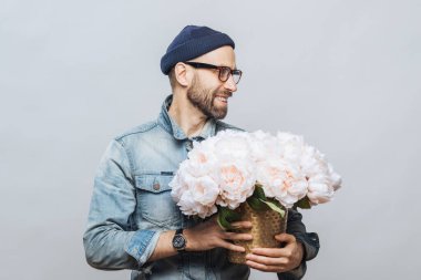 Beyaz çiçek demet mutlu sakallı erkek görünüyor uzakta iken yatay atış tutar, tarihi kız arkadaşıyla yapar onun için mevcut olduğu gibi beyaz arka plan üzerinde olan, iyi bir ruh hali izole.