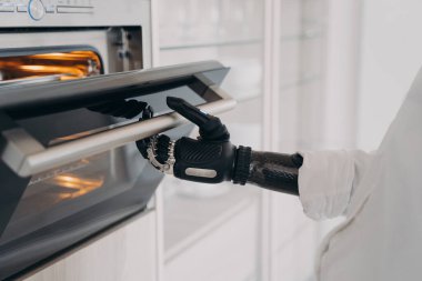 Engelli birinin robot eli mutfakta fırın açıyor ve yemek pişirecek. Yapay biyonik kol. Elektronik parmaklar ve bilek eklemindeki yazılımlar. Engellilerin günlük rutini.