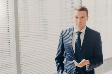 Resmi kıyafetli emin erkek girişimci sohbetleri sosyal ağlarda, mobil internet, indirimi alır ciddi ifadesi olan, profesyonel çalışan varlık başlatma hakkında düşünüyor. Teknoloji kavramı