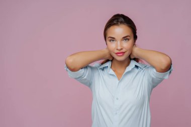 Esmer kadının kapalı çekimleri, makyajı, bakımlı teni ve sağlıklı teni var. Gömlek giyip, erkek arkadaşıyla yürüyecek. Mor duvarın üzerinden izole edilmiş.