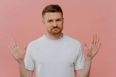 Benim için değil. Beyaz tişörtlü genç mutsuz bir adam hoş olmayan bir yüz ifadesiyle reddedilme hareketi sergiliyor. Pembe arka planda izole bir şekilde duran teklifi reddediyor. İnkar kavramı