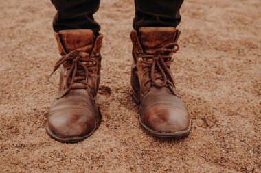 Erkek kadeh kumlu zemin standları, eski shaggy Ayakkabı giymiyor, Ayakkabı göstermektedir. Yatay görünüm. Adam yürüyüş dışında bulunmaktadır. Açık