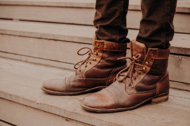 Görüntü kahverengi ayakkabı ayakta ahşap adımlar üzerinde mans. Erkek pantolon ve eşik shaggy ayakkabıları. Yatay görünüm