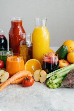 Sağlıklı sebze ve meyve suları veya cam şişelerde smoothie, portakal olgun dilimleri, elma, kırmızı domates, havuç, kereviz, avokado beyaz arka plan izole.