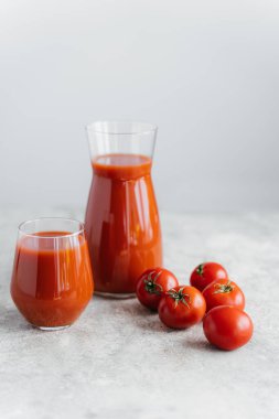 Beyaz arka plan karşı, squezeed lezzetli domates suyu iki bardak yakın Olgun taze kırmızı domates. Malzemeler. Sağlıklı sebzeler