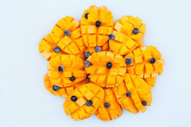 Beyaz arka plan üzerinde izole yaban mersini ile sarı olgun mango küpleri. Taze meyveler. Sağlıklı yiyecekler. Mango dilimleri. Çekimi kapat