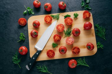 Ketçap yapmak için doğrama tahtası üzerinde bıçak ile Kiraz kırmızı domates dilimleri. Vitamin salatası lezzetli dolu yapmak için organik sebzeler. Vejetaryen yemek