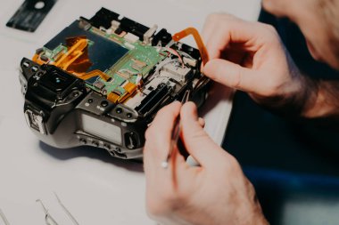 Tanınmayan teknisyen, iş yerinde meşgul, sökük fotoğraf kamera tamir tornavida kullanır. Üst te. Onarım veya onarım işlemi