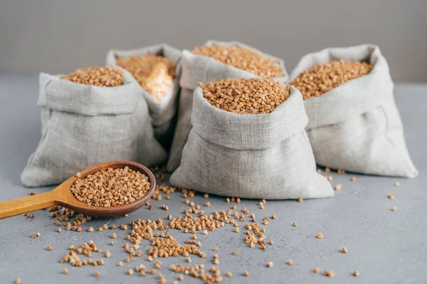Husbandry Concept Raw Buckwheat Sacks Wooden Spoon Splited Cereals Isolated — Stock Photo, Image