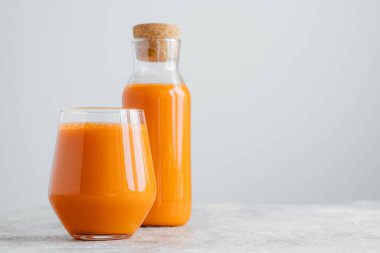 Cam kaplarda taze havuç suyu yatay çekim, vitamin açısından zengin, boş alan ile beyaz duvarda izole. Sebze içeceği