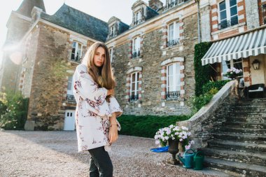 İyi görünümlü ciddi kadın modeller pelerin giyer, antik şatoya karşı poz verir, eski şehirde gezintiye çıkar, tarihi gerçekleri öğrenir, doğanın güzelliğini ve simgelerini takdir eder. Millet, seyahat konsepti