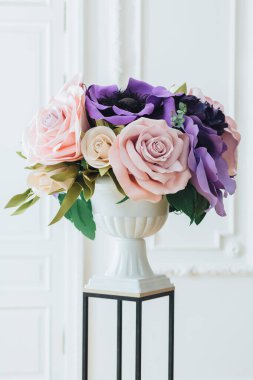 Kutlama çiçek Aranjman beyaz aranjman beyaz bir arka plana dayanır kapalı. Yakın çekim. Güzel buket düğün dekorasyon için. Çiçek kavramı