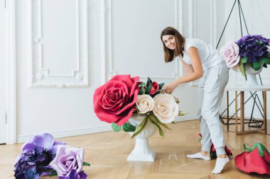 Meşgul kadın kayıtsızca giyinmiş, Festival olay için çiçekli salon süsle. Kadın çiçekçi ziyafet salonu düğün için hazırlar, farklı çiçek kompozisyonlar kullanır