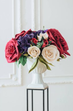 Buket çiçek güllerinin muhteşem ihale kadeh dekorasyon olarak kullanılan ziyafet salonunda beyaz arka plan ayakta. Düğün çiçekleri