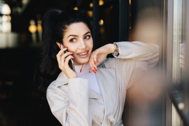 Siyah saçlı ve dolgun dudaklar cep telefonu bir kenara inceliyorlar onun en iyi arkadaşı ile konuşmayı zarif elbise giymiş olan güzel çekici gözler çekici kadın var. İnsanlar, güzellik kavramı