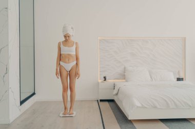 İç çamaşırlı, başını havluya sarmış güzel, genç ve güzel bir kadın yatak odasında tartıda dikilip kilosunu ölçüyordu. Güzellik ve vücut bakımı kavramı