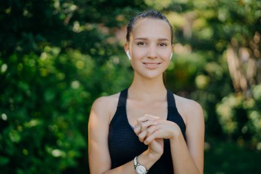 Açık havada çekilen oldukça koyu renk saçlı kadın el ele tutuşur. Fiziksel olarak iyi durumdadır. Spora giderken düzenli olarak spor giysileri giyer.