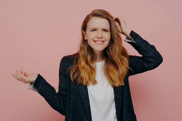 stock image It can not be true. Portrait of young frustrated woman touching head with confused expression, can not believe what she hearing or seeing, dressed in plaid jacket and standing on pink background