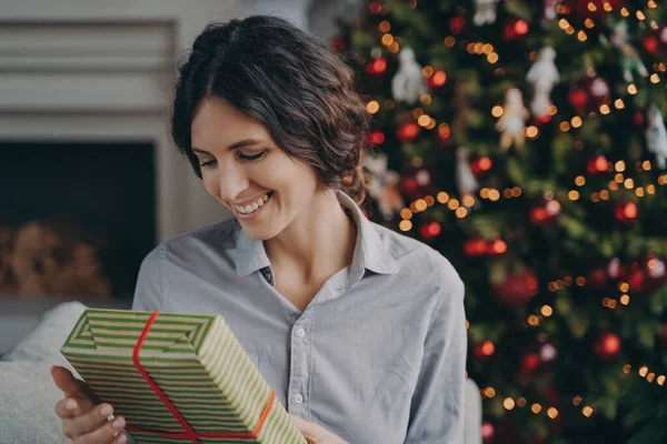 Ευτυχισμένος Ευχαριστημένος Ισπανόφωνη Γυναίκα Κρατώντας Χριστουγεννιάτικο Κουτί Δώρου Ενώ Κάθεται — Φωτογραφία Αρχείου