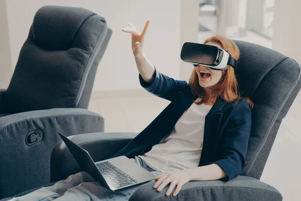 Sorprendida Mujer Pelirroja Excitada Gafas Realidad Virtual Portátil Sentada Sillón — Foto de Stock