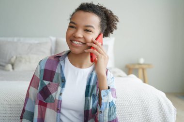Mutlu, Afro-Amerikalı bir kadın evde telefonla konuşuyor. Elinde akıllı telefonuyla gülümseyen melez bir genç kız. Arkadaşlarıyla cep telefonuyla sohbet ediyor..