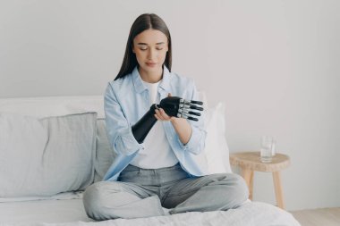 Mutlu engelli kadın elektronik kontrol protezini birleştiriyor ve işlemci çipiyle işlevleri ayarlıyor. Avrupalı kız yapay kolunu ayarlıyor. Özürlülerin günlük rutini için yenilik.