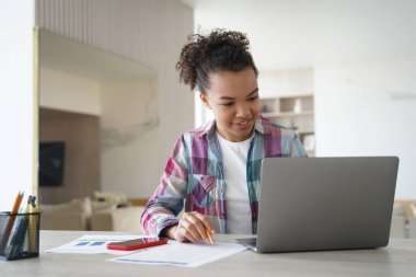 Uzaktan öğrenme çevrimiçi. Mutlu afro kız zoom 'da uzaktan çalışıyor. Genç kız dizüstü bilgisayarın önünde oturmuş video konferansı yapıyor. Okulda ya da üniversitede uzaktan eğitim. Coronavirus karantinası.