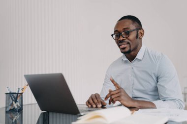 Kind boss, businessman in formal wear has online meeting in zoom. African american man is speaking in front of camera. Distant work at home concept. Remote conference or lesson.
