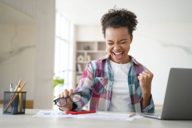 Heyecanlı mutlu Afro-Amerikan liseli kız, zaferi kutluyor, sınav sonuçları iyi olan bir e-posta aldı. Aşırı neşeli melez ergen öğrenci internette iyi haberler aldı. Uzaklık eğitimi
