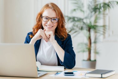 Mutluluk neşeli kırmızı haird kadın ekonomist mali başlangıç proje geliştirir, ofis iç teşkil etmektedir, resmi kıyafetler giymiş iş alanında çalışır, mutlu ifadesi olan, şirket sahibi