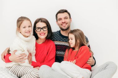 Mutlu aile kapalı atış beraberlik zevk, yedek zaman hafta sonu evde sırasında dergiye poz. Memnun tıraşsız adam, eşi ve iki küçük kızı beyaz stüdyo arka plan üzerinde izole