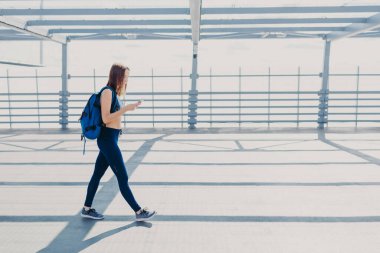 İyi görünümlü sporcumuz gündelik kıyafet, taşır sırt çantası, modern teknolojileri, dokunmatik, her zaman için bağımlı giymiş yatay atış en sevdiğim şarkıyı dinler. Aktif yaşam tarzı kavramı
