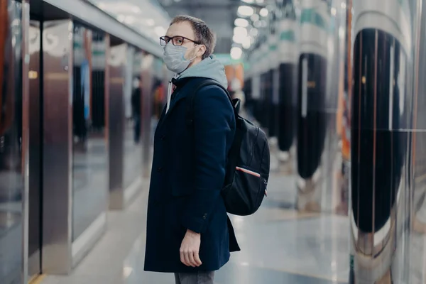 장소에서의 의료용 마스크를 남자가 지하철 배낭을 전염병 창궐하는 상황에서 스러운 — 스톡 사진