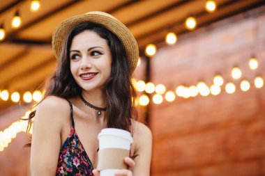 Paket servisi olan restoran kahve ya da çay bir kenara açık kafe dinlenme onun erkek arkadaşı fark mutlu olmak gülümseme ile seyir tutarak utangaç esmer kadın, koyu renk gözleri ve hasır şapka ve elbise, kırmızı dudaklar