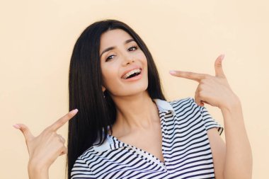 Mutlu muhteşem kadın modeli portresi gösterir ile ön plana parmak yüzüne, diş telleri bile dişler için tanıtır, karanlık uzun düz saçlı, gözleri ve mükemmel sağlıklı cilt parlak, kapalı modelleri